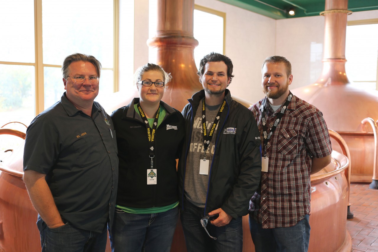 In the brewhouse at Summit Brewing Company. Standing next to his iconic copper brewing tanks is President Mark Stutrud along with Lodge Manager Olivia Stenvold, Phillip Breker and Chef Daniel Miles.